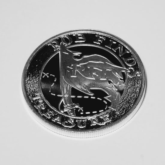 video of 2023 RFT Custom Silver Round, Rob Finds Treasure Custom Silver Round on white background showing reflection of  front of coin